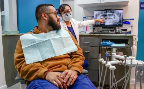 A dentist consulting a patient about their care during an appointment.
